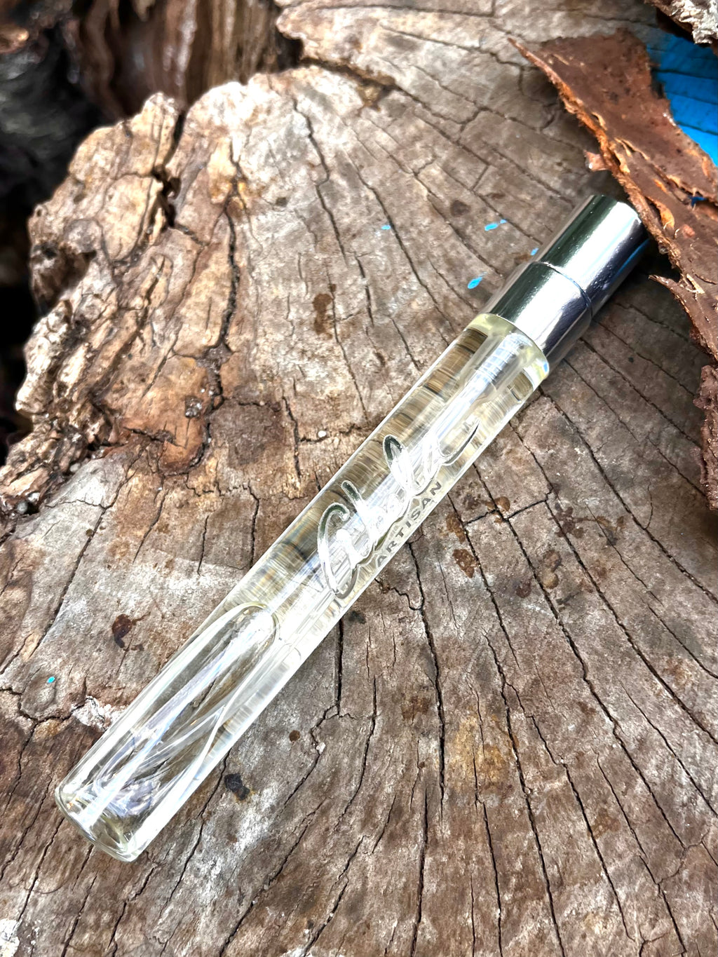 Clear glass pen with silver cap on a wooden surface