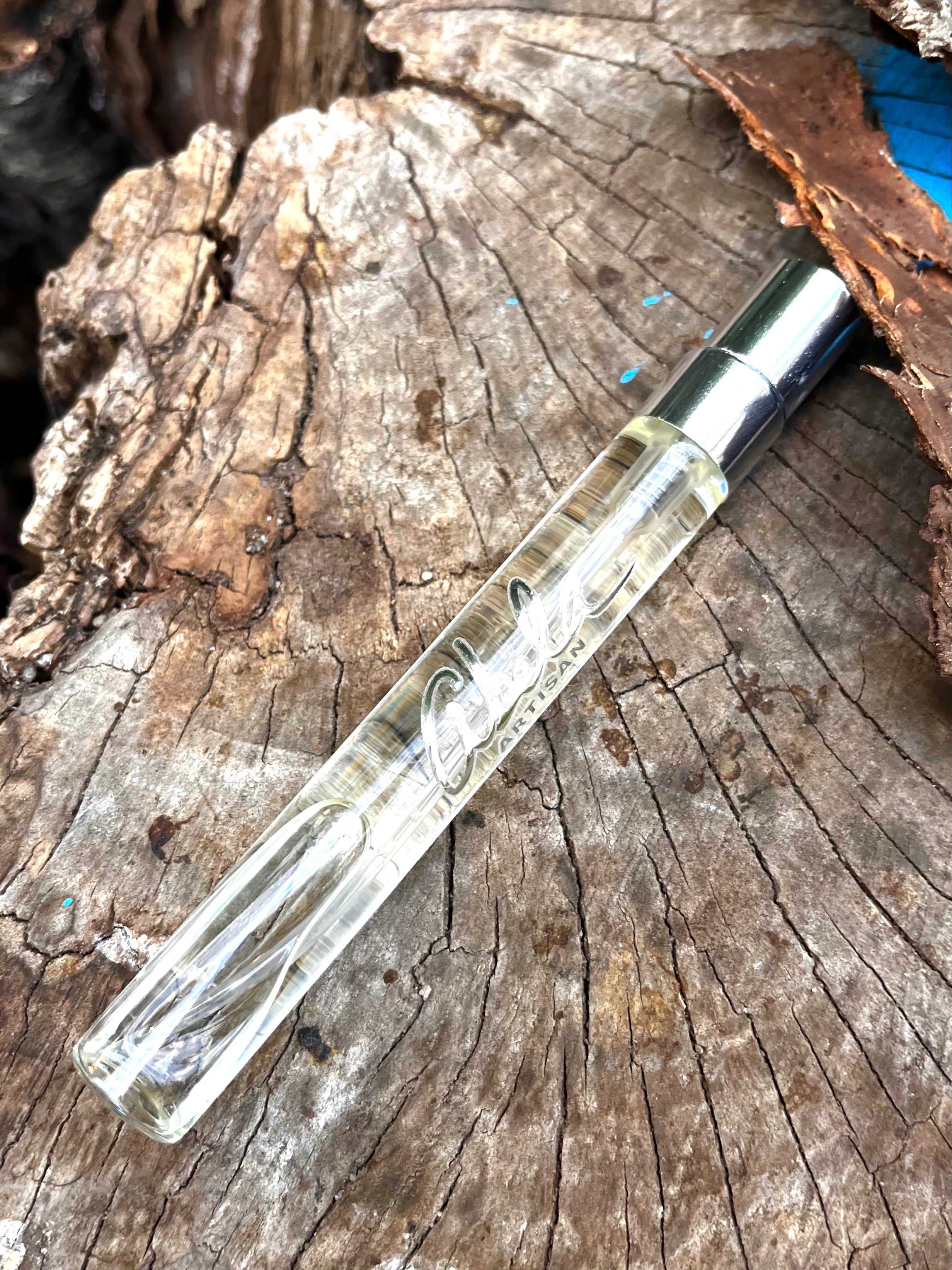 Clear glass pen with silver cap on a wooden surface